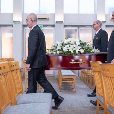 Pallbearers holding a coffin in a church